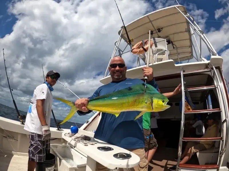 Angler holding a dorado on a Cancun fishing trip