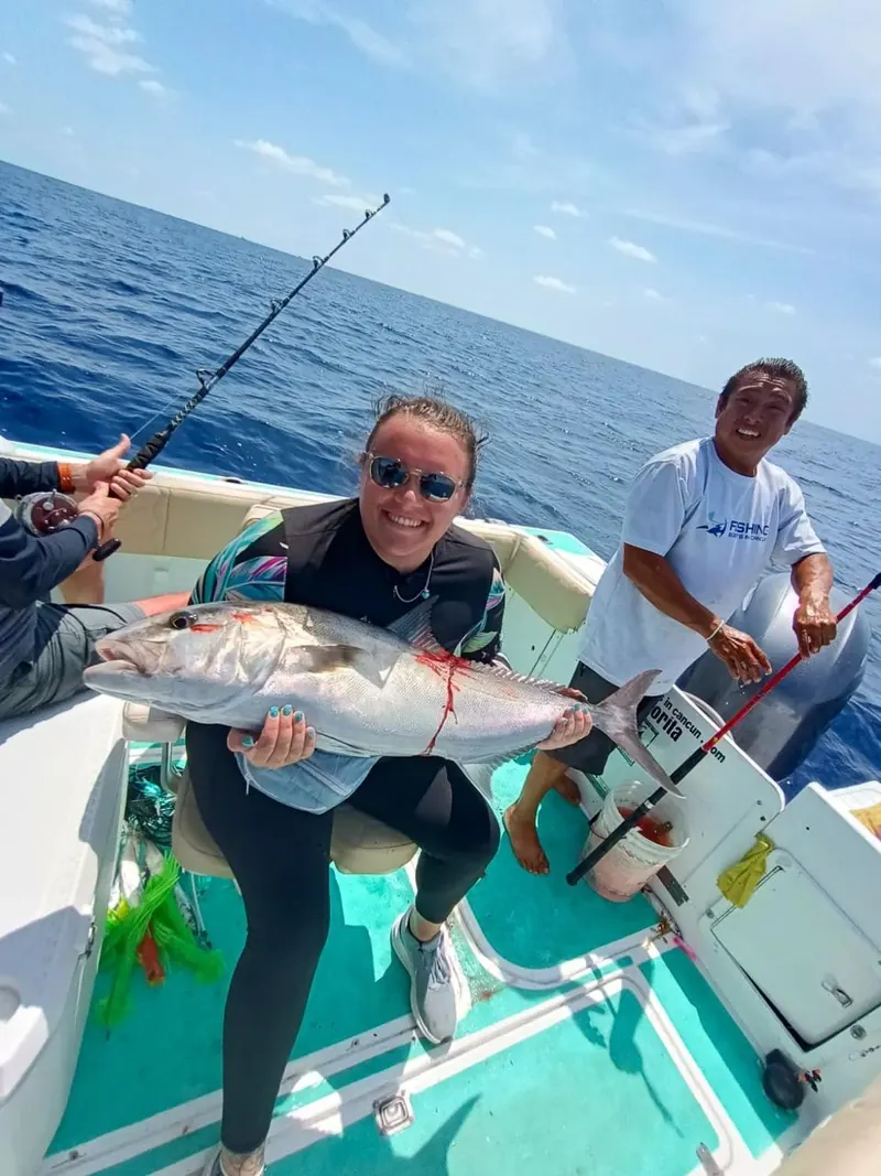 Angler and crew showing a fish caught on a fishing trip